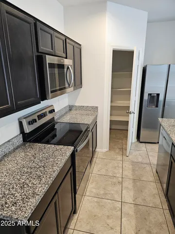 a kitchen with stainless steel appliances granite countertop a refrigerator stove and sink