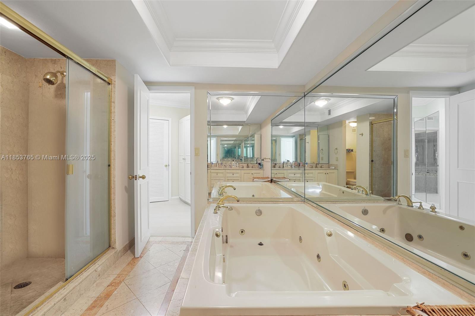 1121 Crandon Boulevard, Unit E802 Key Biscayne, FL 33149 - Photo 16 of 31 a large bathroom with a tub a double vanity sink and mirror