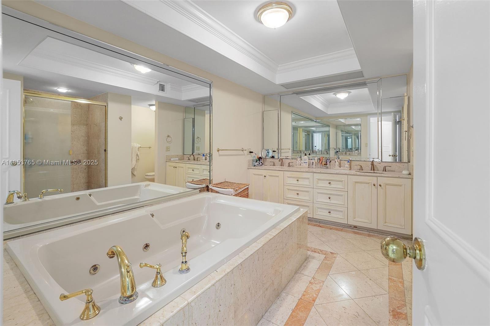 1121 Crandon Boulevard, Unit E802 Key Biscayne, FL 33149 - Photo 17 of 31 a bathroom with a tub a double vanity sink and mirror