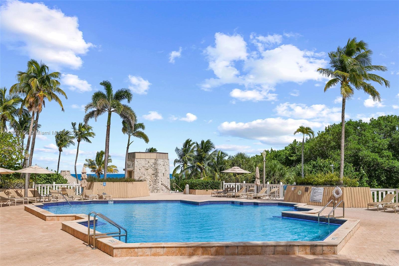 1121 Crandon Boulevard, Unit E802 Key Biscayne, FL 33149 - Photo 25 of 31 a view of a swimming pool with a patio and a garden