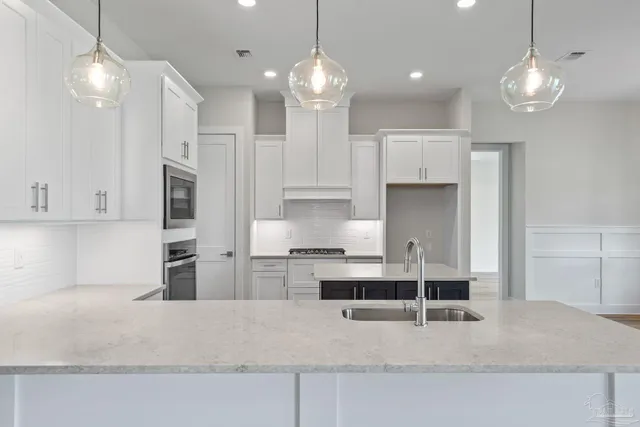 a kitchen with kitchen island white cabinets and refrigerator