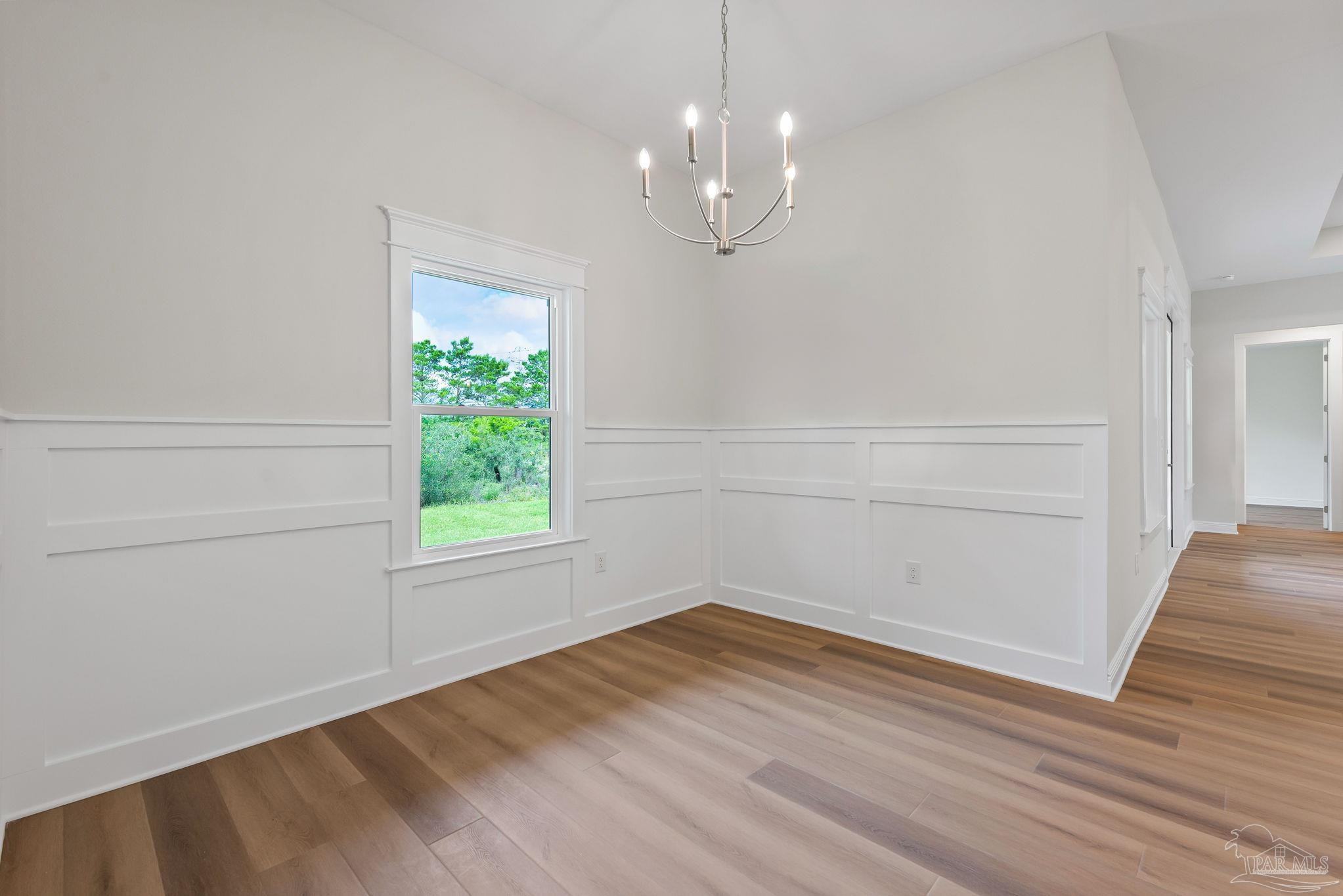 2038 Fontainebleau Court Navarre, FL 32566 - Photo 4 of 8 wooden floor in an empty room with a window