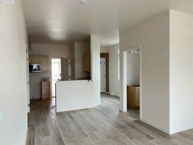 a view of a kitchen refrigerator and wooden floor