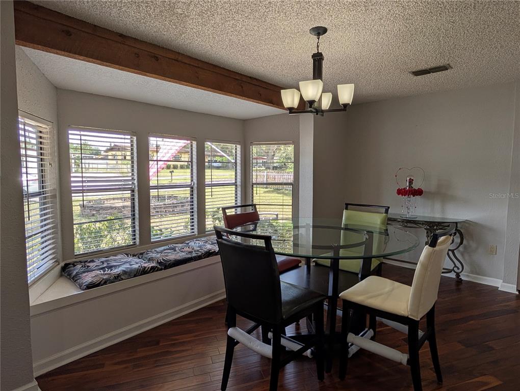 5508 Bryson Drive Orlando, FL 32818 - Photo 24 of 69 a view of a dining room with furniture a chandelier and wooden floor