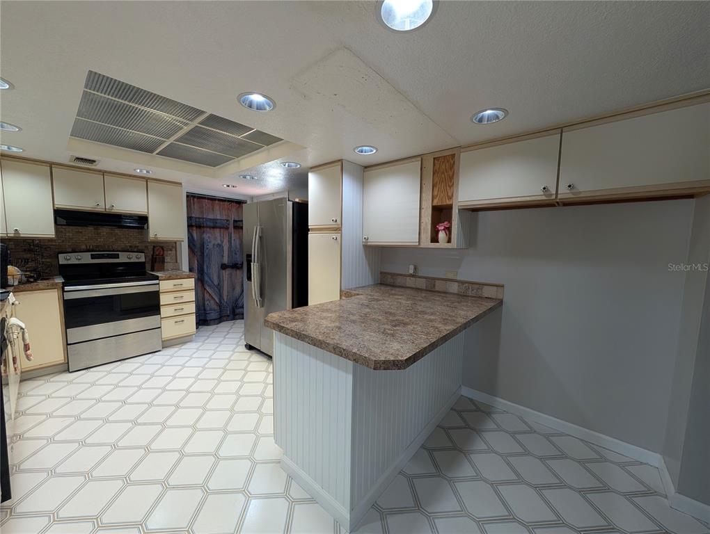 5508 Bryson Drive Orlando, FL 32818 - Photo 31 of 69 a kitchen with stainless steel appliances granite countertop a sink and a stove