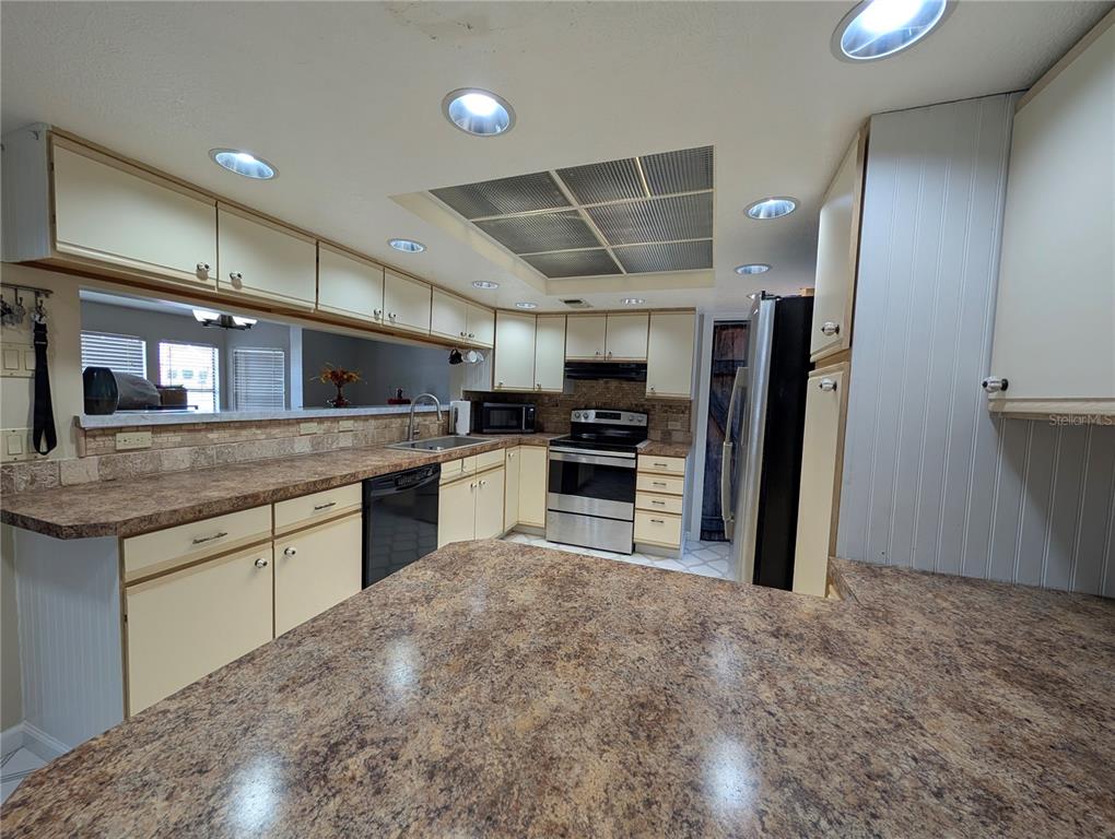 5508 Bryson Drive Orlando, FL 32818 - Photo 32 of 69 a kitchen with stainless steel appliances granite countertop a stove sink and refrigerator