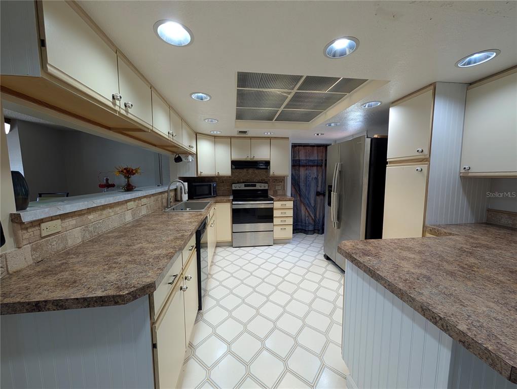 5508 Bryson Drive Orlando, FL 32818 - Photo 33 of 69 a kitchen with stainless steel appliances granite countertop a sink and a refrigerator
