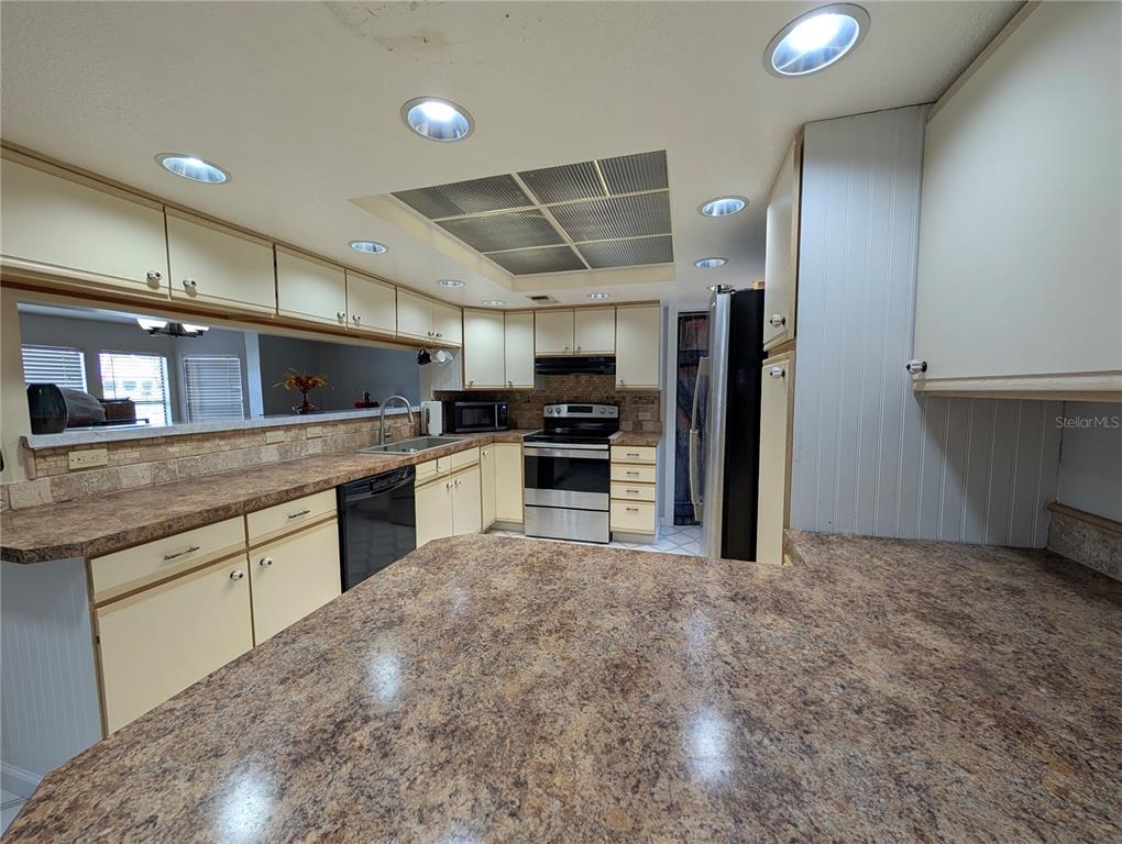 5508 Bryson Drive Orlando, FL 32818 - Photo 34 of 69 a kitchen with a sink stainless steel appliances and cabinets