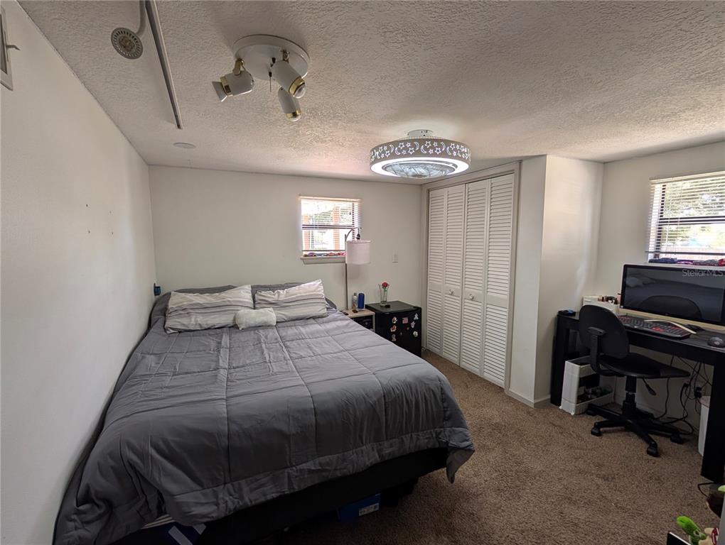 5508 Bryson Drive Orlando, FL 32818 - Photo 51 of 69 a bedroom with a bed and a chandelier