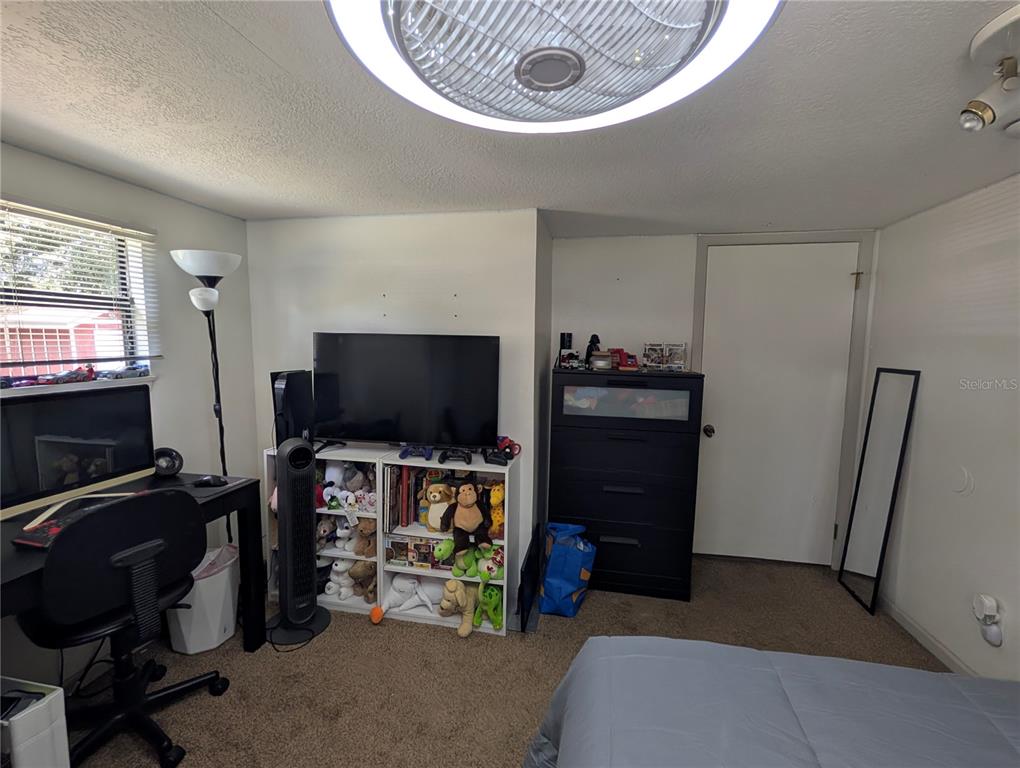 5508 Bryson Drive Orlando, FL 32818 - Photo 53 of 69 a bedroom with a bed and a flat tv screen