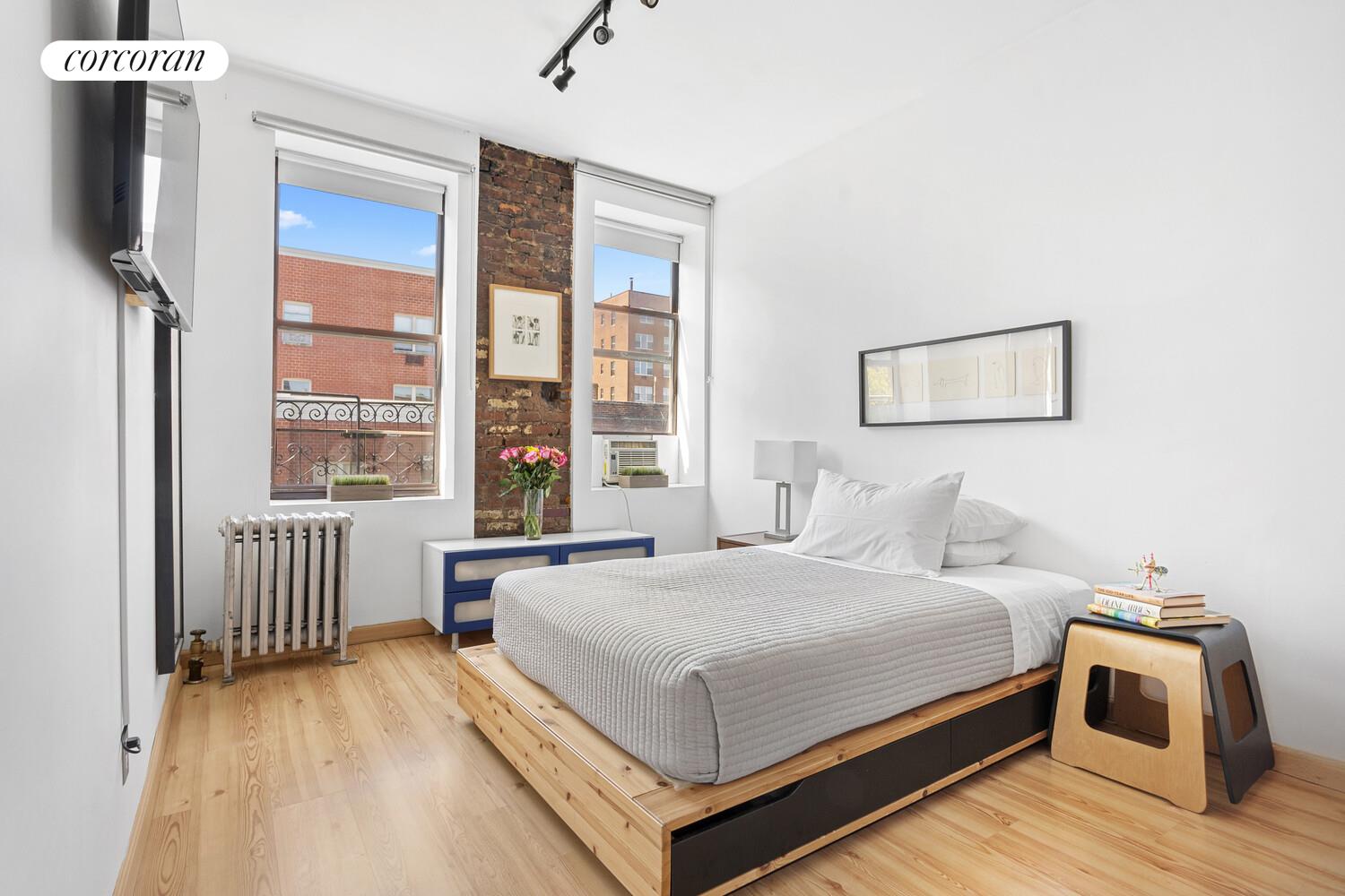 311 East 3rd Street, Unit 33 Manhattan, NY 10009 - Photo 2 of 7 a bedroom with a bed and a large window