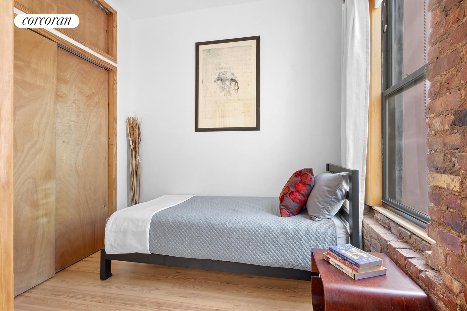 311 East 3rd Street, Unit 33 Manhattan, NY 10009 - Photo 5 of 7 a bedroom with a bed and a couch next to a window