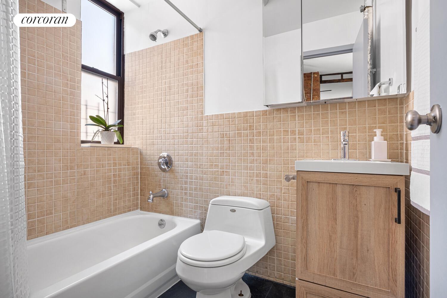 311 East 3rd Street, Unit 33 Manhattan, NY 10009 - Photo 6 of 7 a bathroom with a toilet a sink and bathtub