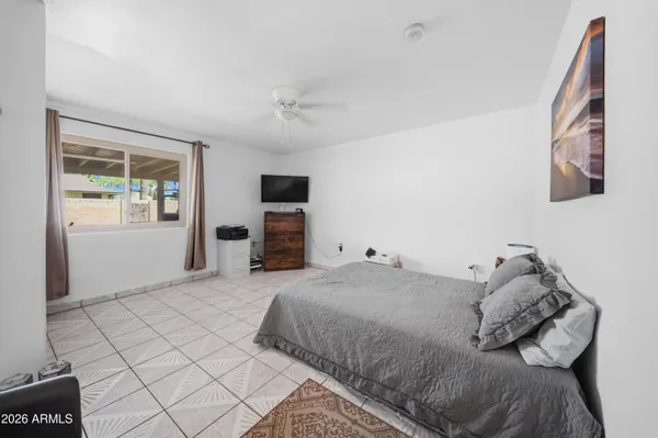 a bedroom with a bed and a tv on the dresser