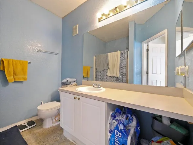 a bathroom with a sink a toilet and mirror