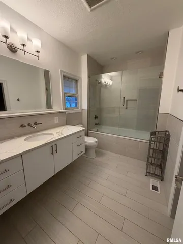 a bathroom with a double vanity sink a mirror and a bathtub