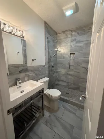 a bathroom with a sink a toilet and shower