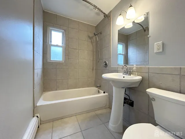 a bathroom with a sink a toilet a mirror and bathtub