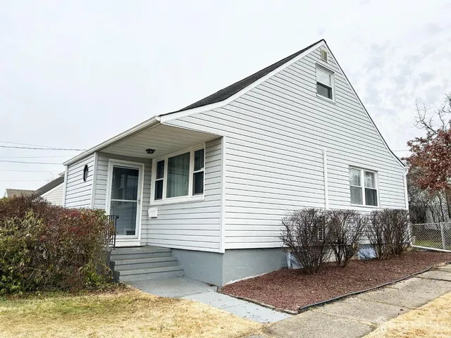 a view of a house with a yard and sitting area