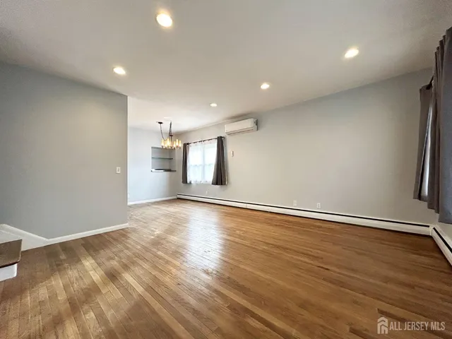 an empty room with wooden floor and window