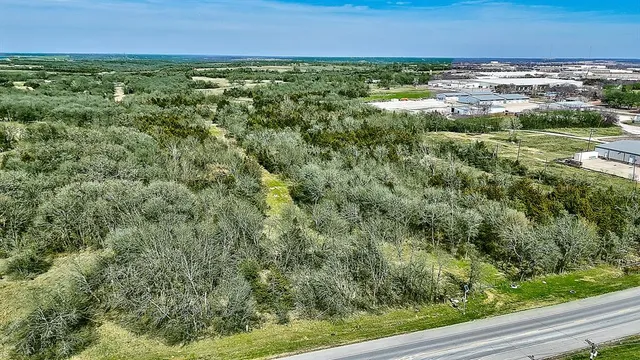 an aerial view of residential houses with outdoor space and trees
