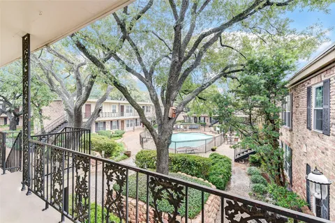 a view of a house with large trees in front of it
