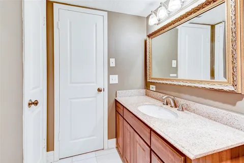 a bathroom with a sink vanity granite and a mirror