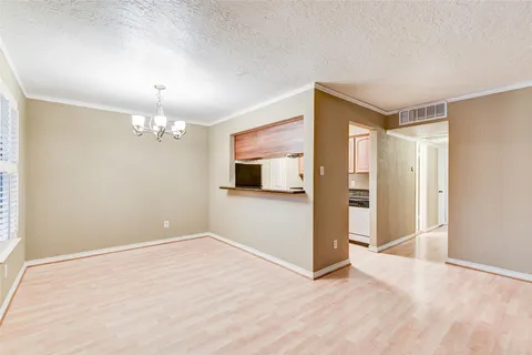 a view of a room with wooden floor and chandelier