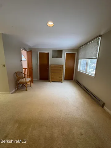 a view of an empty room with a fireplace and a window