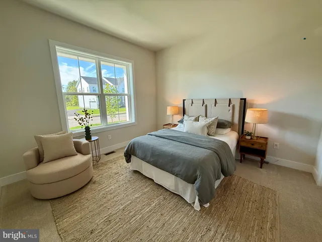 a bedroom with bed couch and window