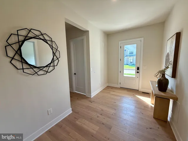 a view of a livingroom with wooden floor and a bathroom