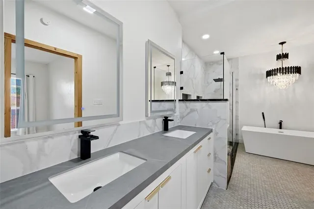 a bathroom with a tub sink and mirror