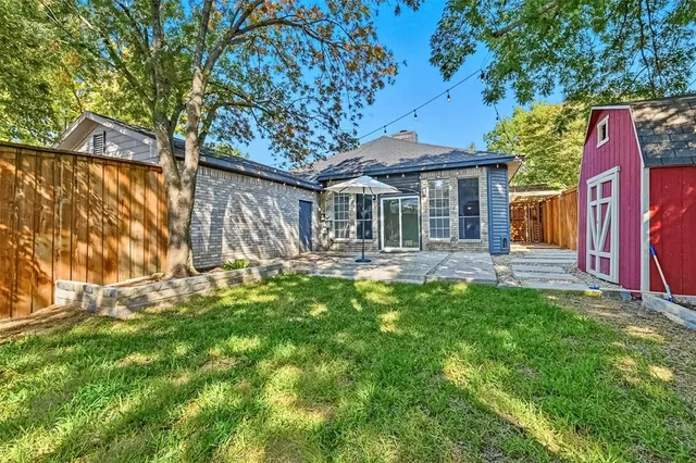 a view of a small yard in front of a house with wooden fence