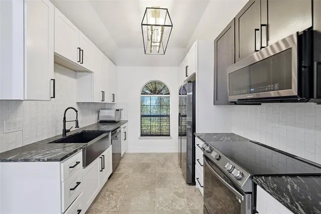 a kitchen with stainless steel appliances granite countertop a stove a sink and a microwave