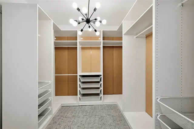 a view of walk in closet with empty racks