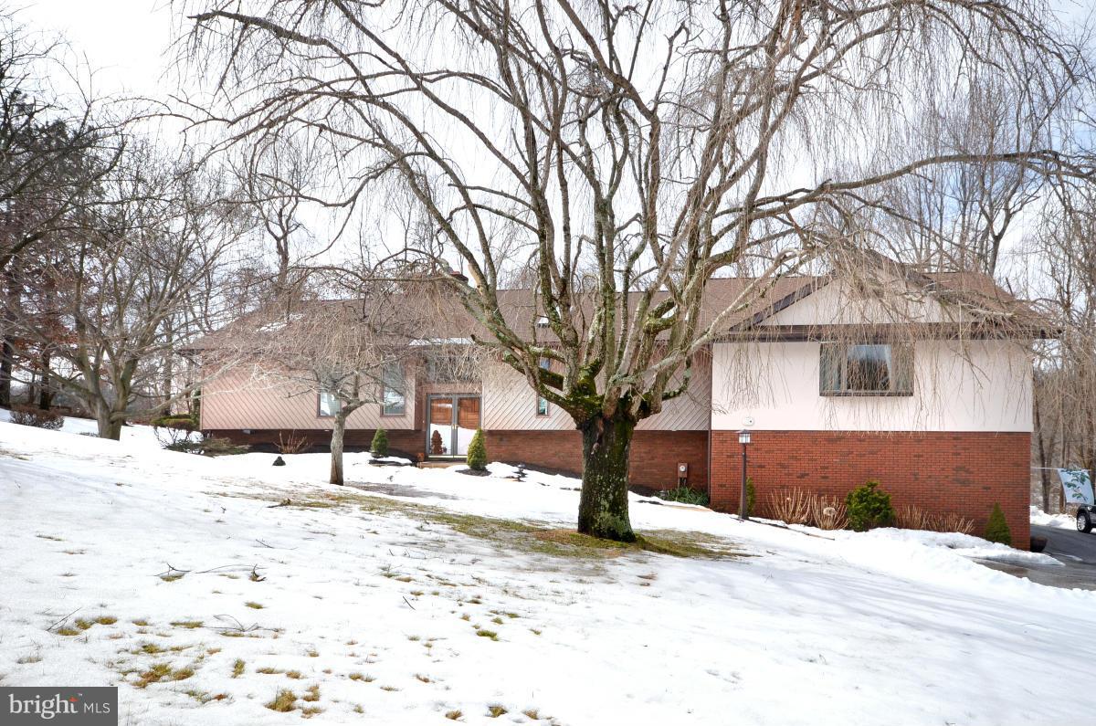 a front view of a house with a yard covered with snow