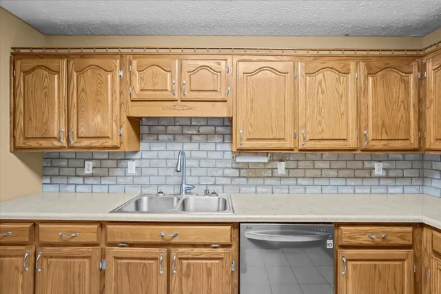 a kitchen with stainless steel appliances granite countertop white cabinets a sink and dishwasher