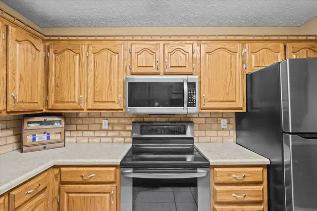 a kitchen with granite countertop white cabinets and stainless steel appliances