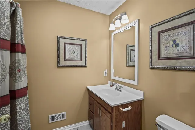 a bathroom with a toilet a sink and mirror