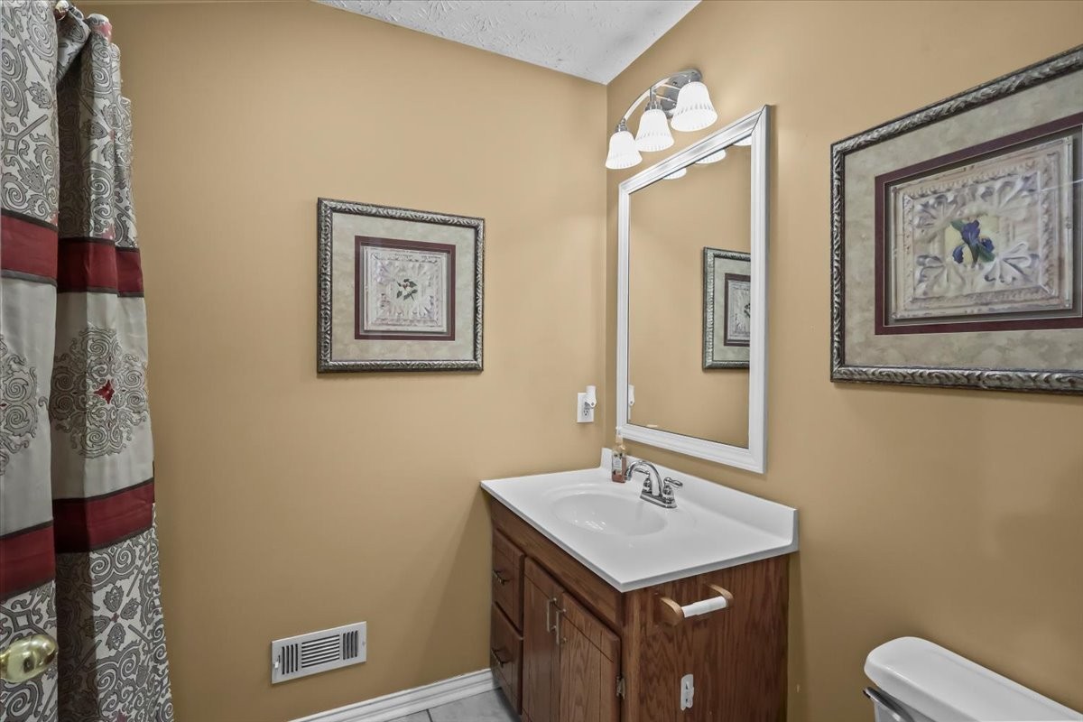 2981 Rocky Hill Road Smiths Grove, KY 42171 - Photo 21 of 31 a bathroom with a toilet a sink and mirror