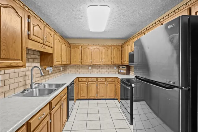 a kitchen with a refrigerator a sink and cabinets