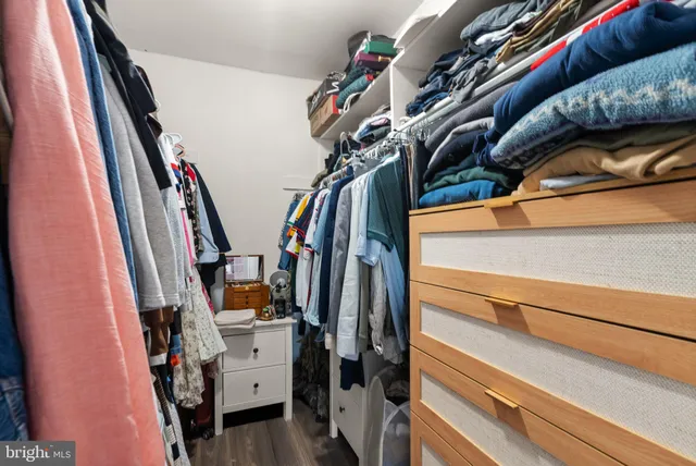 a view of walk in closet with clothes and shoes