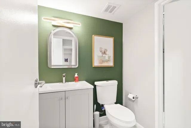 a bathroom with a toilet a sink and mirror