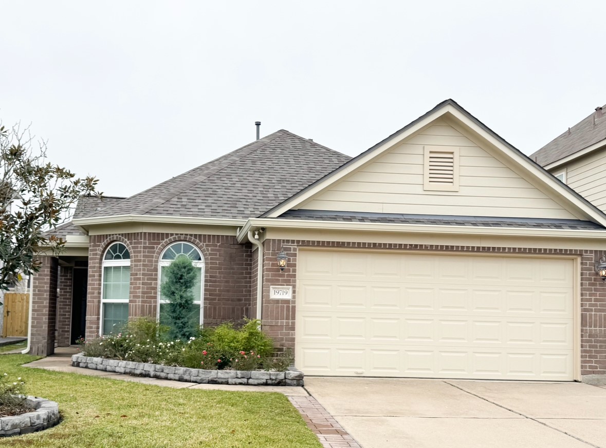 a view of house with garage and plants