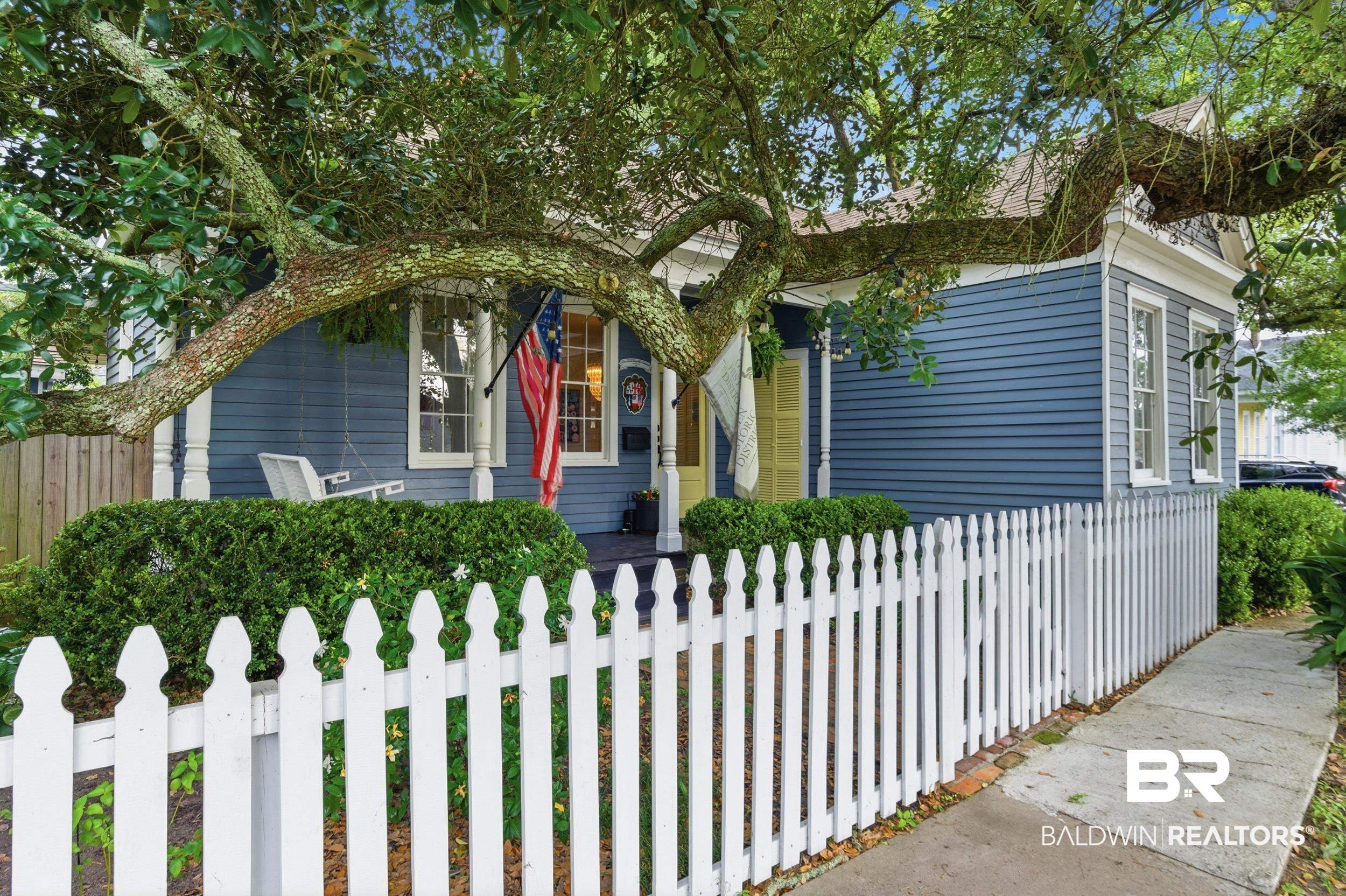 350 Charles Street Mobile, AL 36604 - Photo 3 of 52 Charming exterior featuring blue horizontal siding and a classic white picket fence