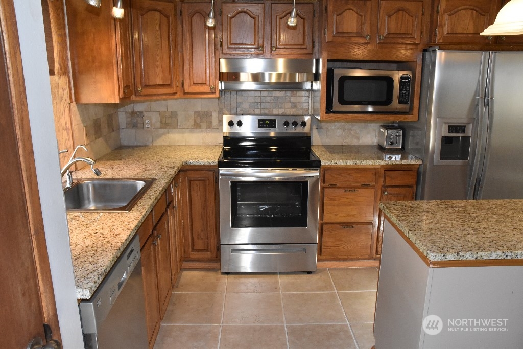 422 South 26th Street Renton, WA 98055 - Photo 7 of 24 a kitchen with stainless steel appliances granite countertop a sink stove and refrigerator