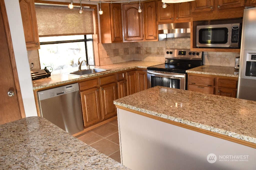 422 South 26th Street Renton, WA 98055 - Photo 8 of 24 a kitchen with stainless steel appliances granite countertop a sink stove and microwave
