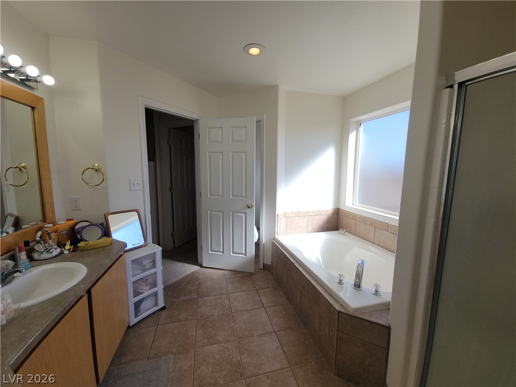 768 Weiser Ridge Street Overton, NV 89040 - Photo 16 of 37 Primary bathroom featuring a water closet, garden tub, separate shower and tile flooring