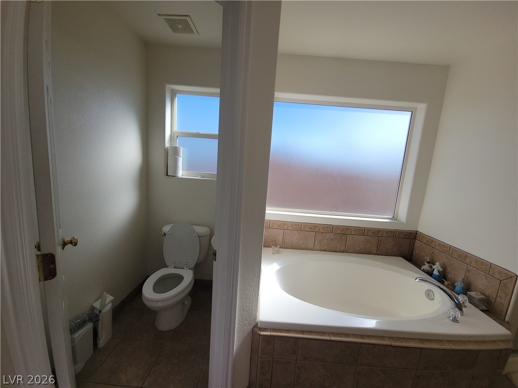 768 Weiser Ridge Street Overton, NV 89040 - Photo 17 of 37 Primary bathroom featuring a water closet, garden tub and tile flooring
