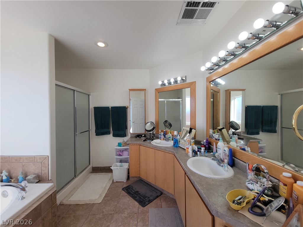 768 Weiser Ridge Street Overton, NV 89040 - Photo 18 of 37 Primary bathroom featuring a shower stall, double vanity, a garden tub, light tile patterned flooring, and recessed lighting